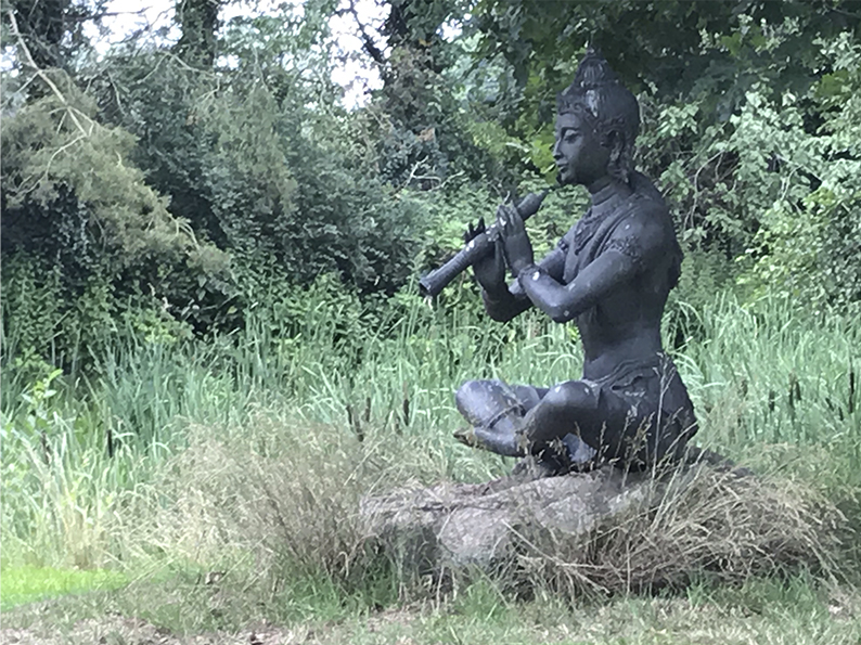 Eine Buddha-Statue im Grünen.