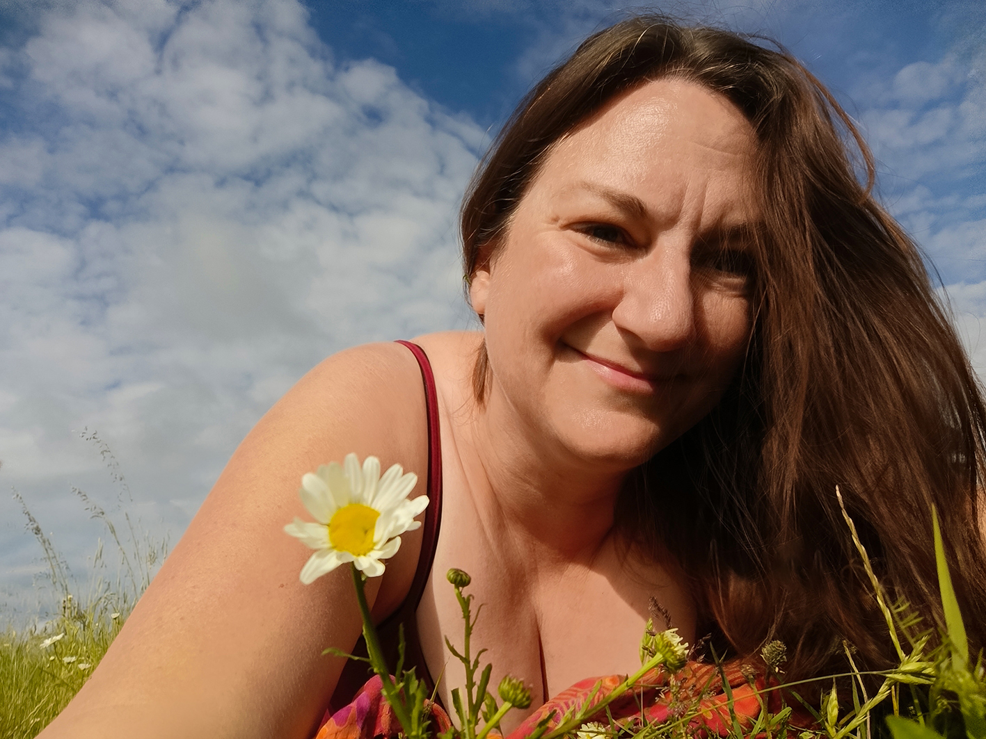 Tesst liegt auf einer Blumenwiese und schaut verträumt in die Kamera